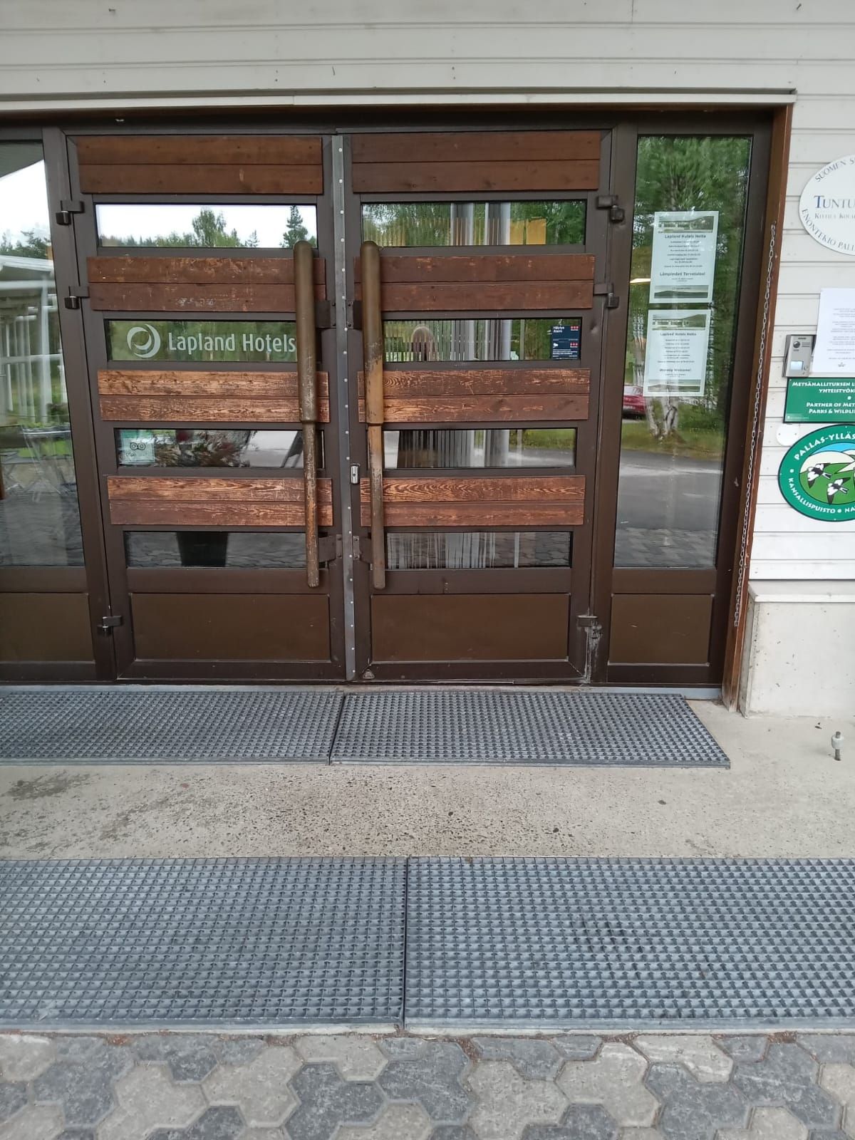 Two brown doors with two long vertical wooden handles either side